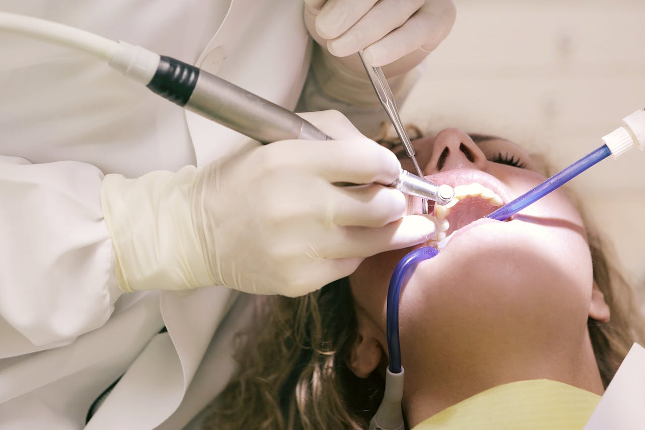 our-services-2 Close-up of a dental procedure with tools in a clinic setting, patient undergoing treatment.