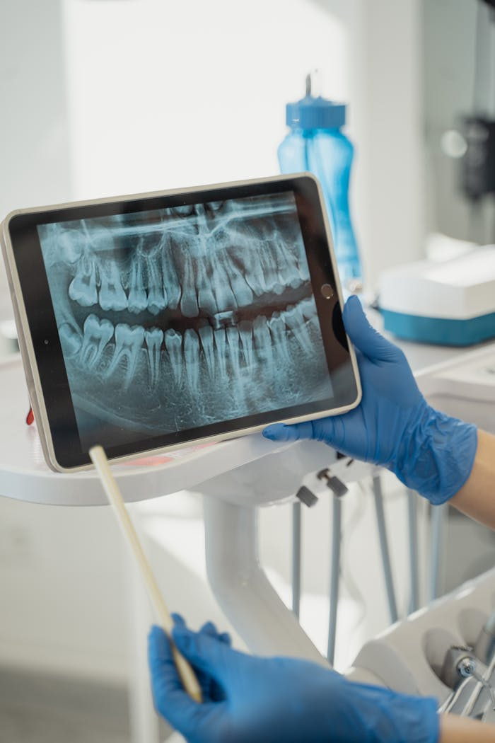 hero-img-02 Dentist displaying dental x-ray on tablet in a modern clinic.